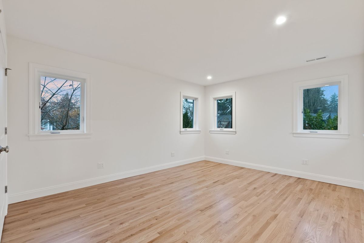 Second-floor bedroom with dormer windows and white oak floors