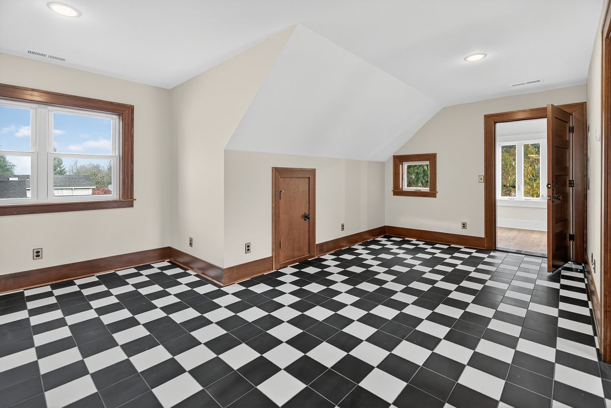 Upper-floor ADU living space with checkerboard tile under a vaulted ceiling