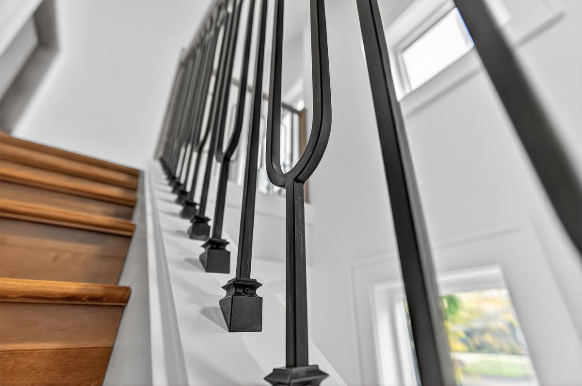 Detail of black metal baluster and alder tread