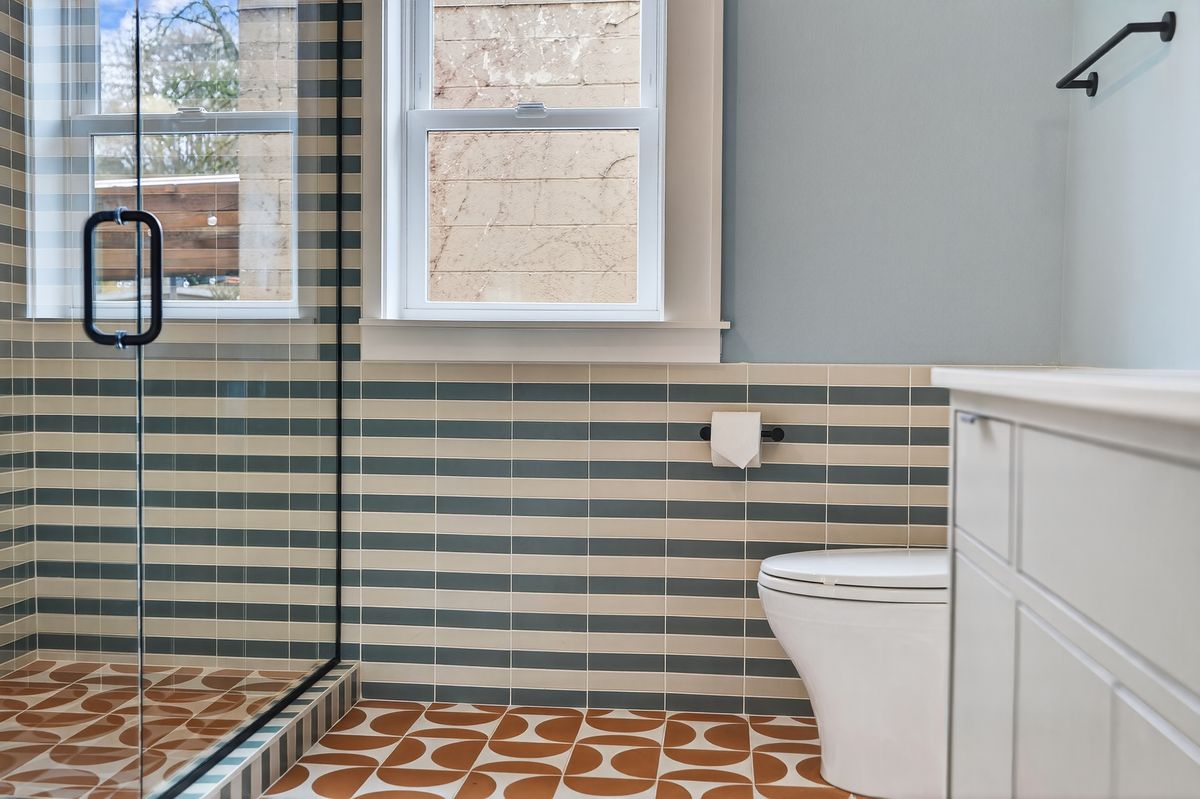 Main bath shower with glass enclosure and striped tile