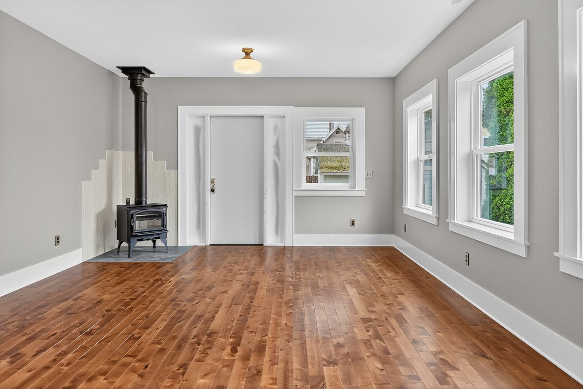 Living room of a finished Portland Project home with wood stove and alder floors