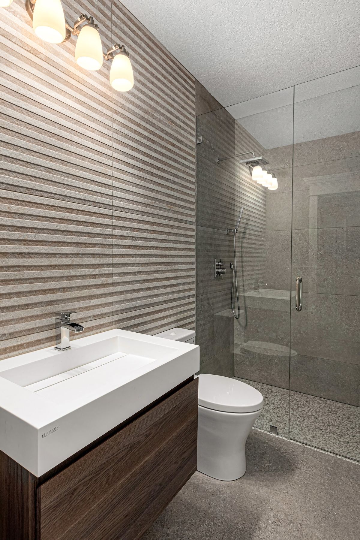Remodeled bathroom: floating walnut vanity, vessel sink, grey tile and glass shower