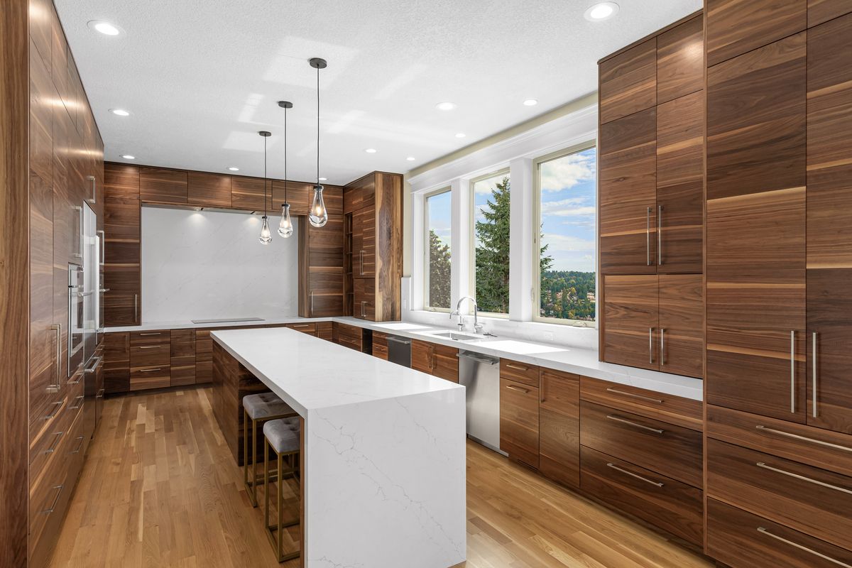 NW Skyline kitchen remodel — walnut cabinetry, quartz waterfall island and hillside view
